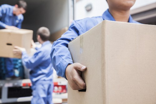 Mover carrying boxes from a Kingston upon Thames apartment