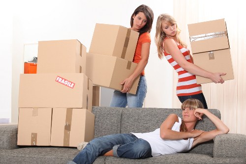 Team lifting furniture using correct manual handling techniques
