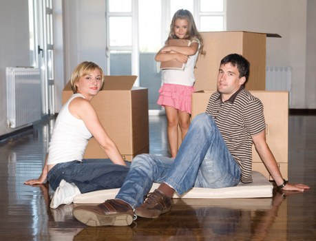 Piano movers using straps, blankets, and a trolley for secure transport
